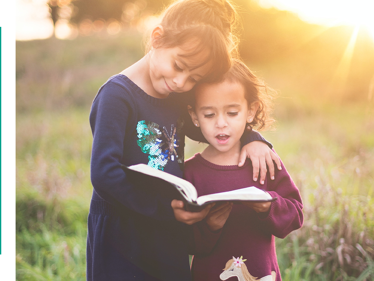 Two children reading outside.