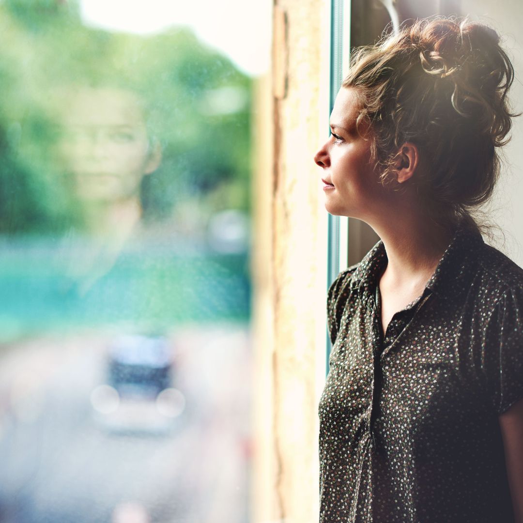 a woman looking out the window pensively